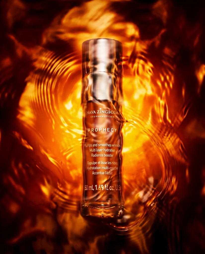 Amber serum bottle over glowing golden ripples