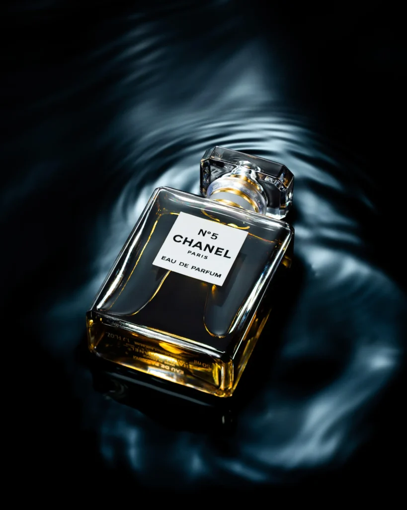 Square glass perfume flask half-submerged in dark rippling water
