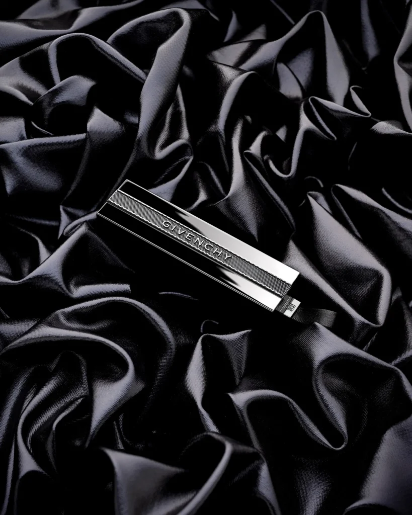 Slim silver cosmetic case on folds of black silk