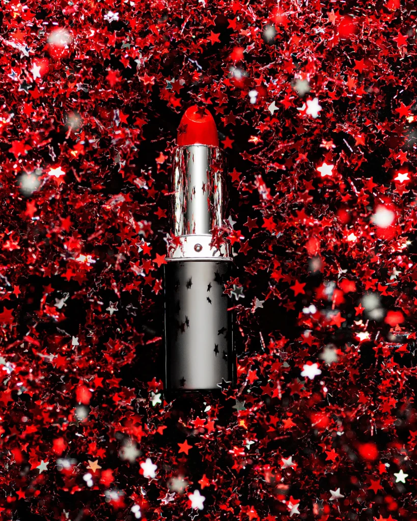 Lipstick lying on a field of red and silver star confetti