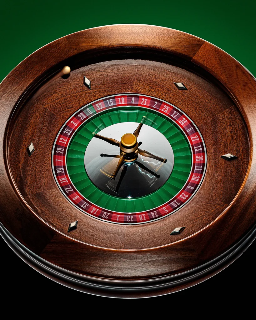 Overhead view of a wooden roulette wheel on green baize