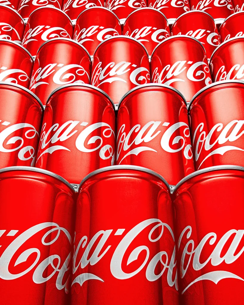 Tightly packed rows of red soft-drink cans filling the frame