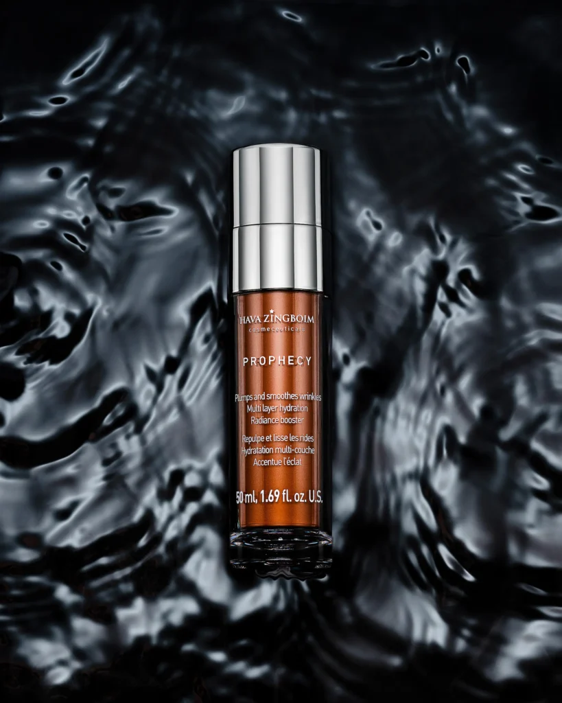 Slim serum bottle standing in dark rippling water