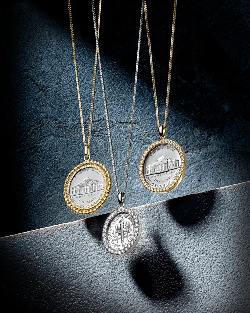 Three medallion pendants on fine chains against grey stone