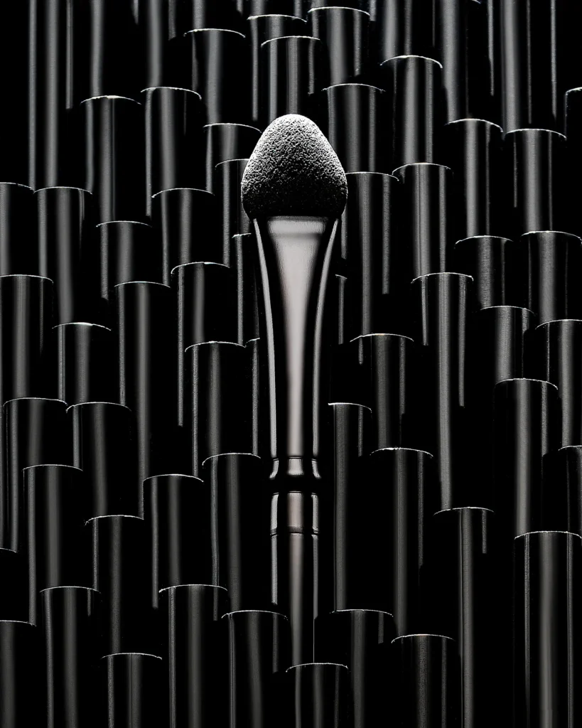 Powder brush rising from a field of black cylinders
