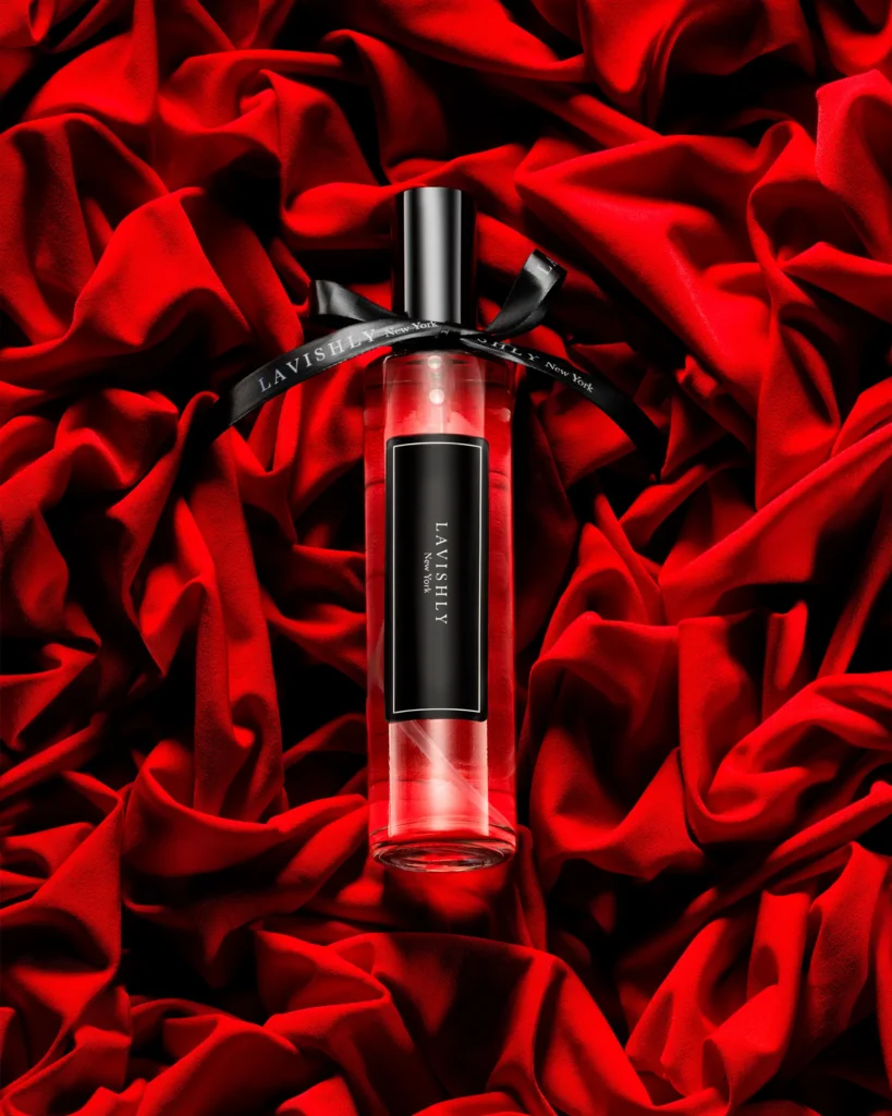 Black and red fragrance bottle with a ribbon on red velvet