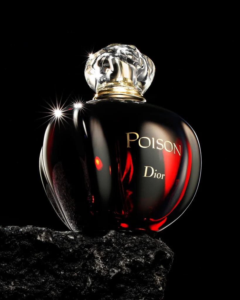 Dark perfume flask with a faceted stopper catching two star highlights
