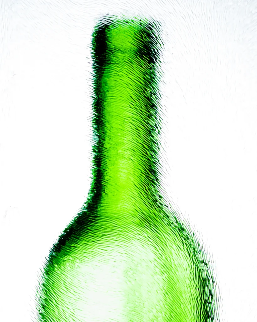 Abstract close crop of a green glass bottle neck on white
