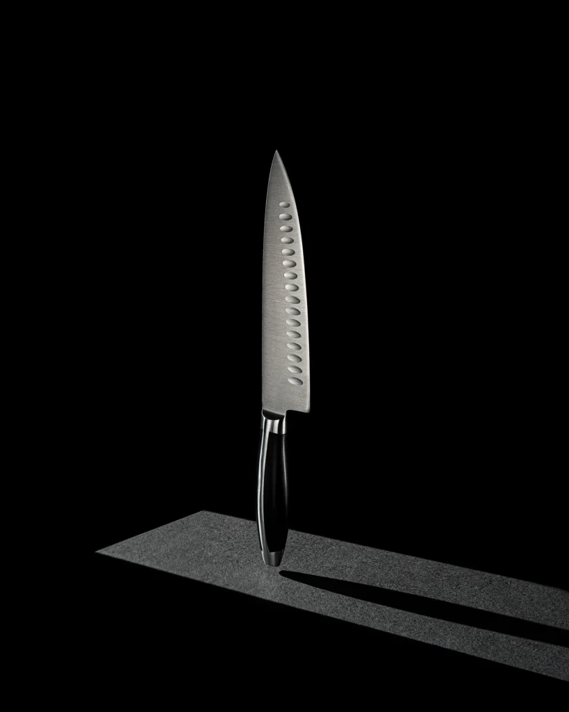 Kitchen knife standing upright on a black plinth