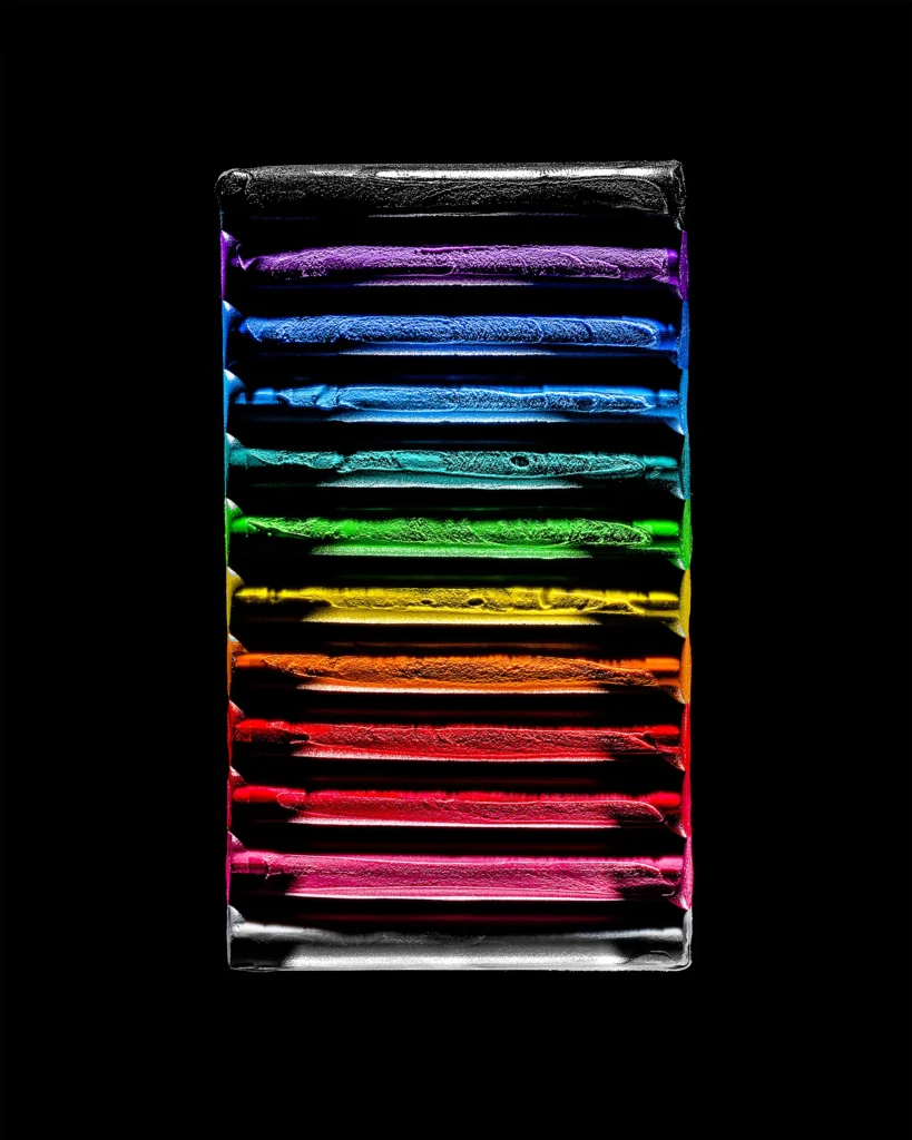 Stacked bars of pigment in rainbow order on black