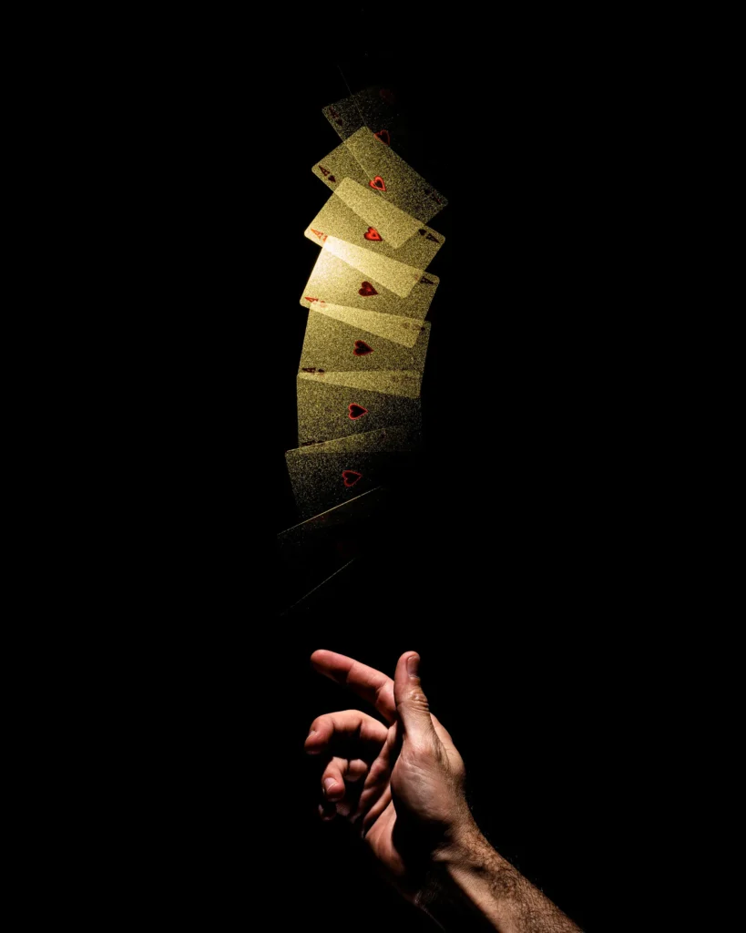 Gold playing cards falling toward an open hand