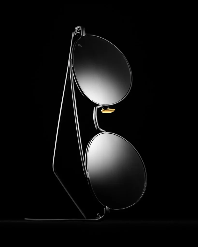 Round mirrored sunglasses standing open on black