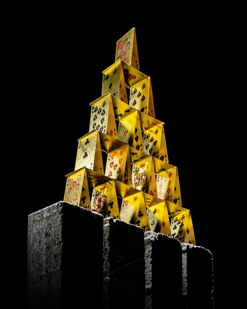 Pyramid of gold playing cards on concrete blocks