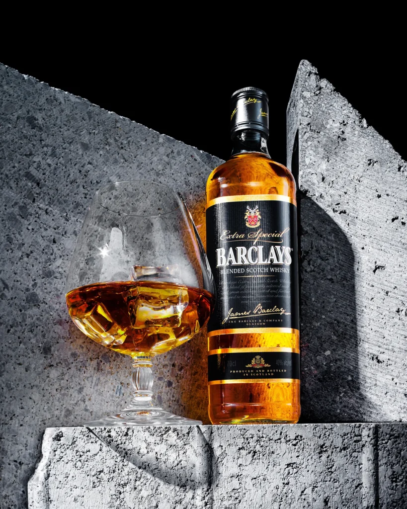 Whisky bottle and glass on split grey stone