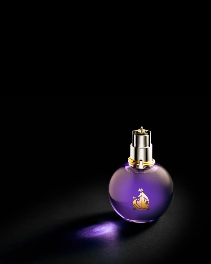 Round purple perfume bottle lit on black