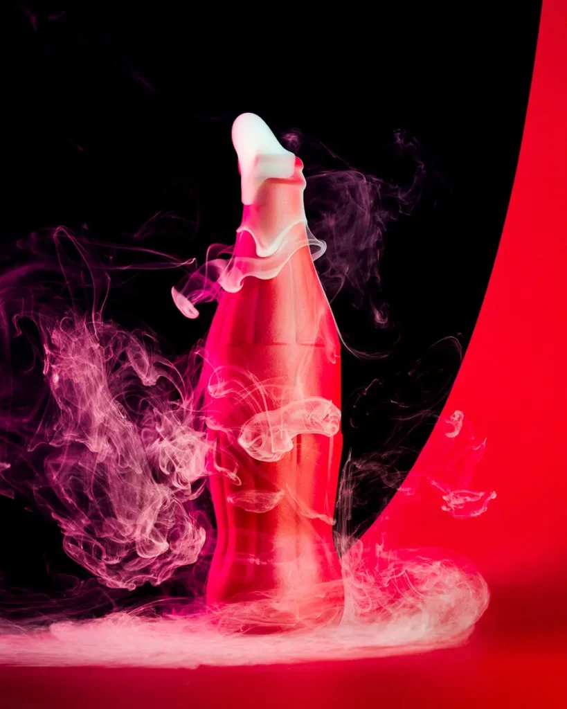 Pink bottle form rising from smoke against red