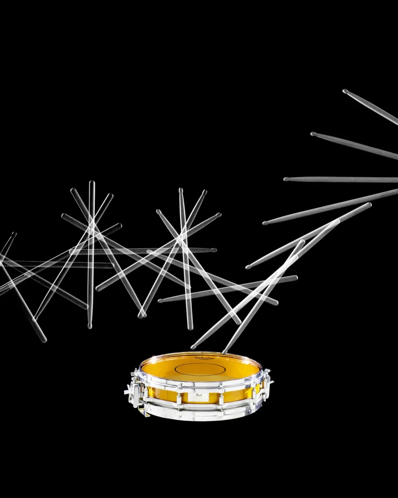 Snare drum with drumsticks radiating outward on black