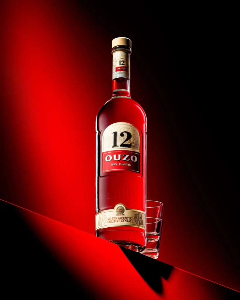 Aniseed spirit bottle and glass on a red and black diagonal (retouched)