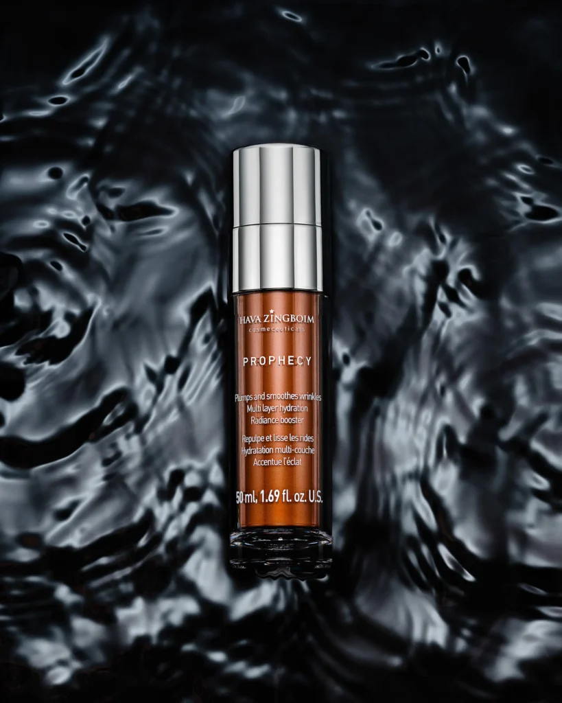 Slim serum bottle standing in dark rippling water (retouched)
