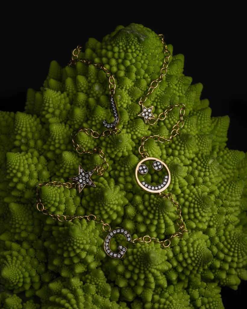 Gold charm chain laid over green romanesco florets (unretouched original)