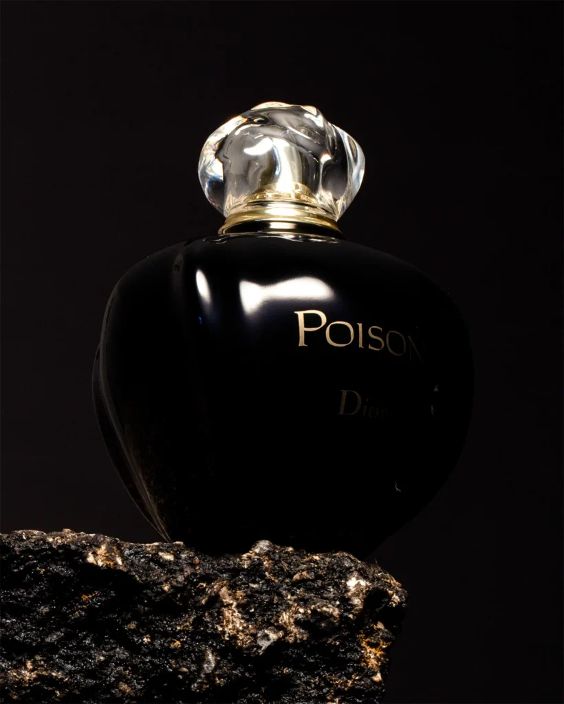 Dark perfume flask with a faceted stopper on volcanic rock (unretouched original)